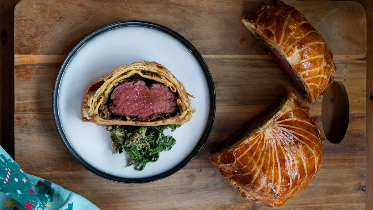 perfect beef wellington sliced showing pink medium rare centre with golden puff pastry mushroom duxelles