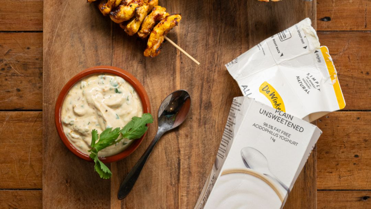 creamy yoghurt dressing in white bowl with fresh coriander 