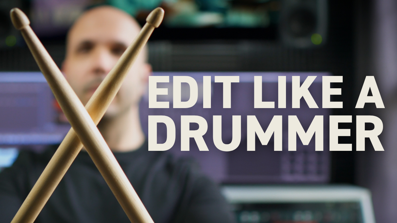 Pro editor holding up a pair of drum sticks in front of his edit suite.