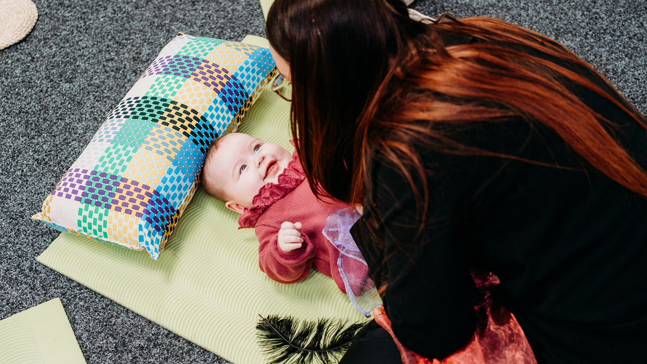 Baby and adult connecting during a multi sensory baby development class that supports early brain development and emotional connection.