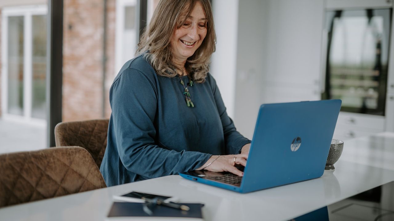 Elizabeth James, founder of The Baby Class Expert, working at her desk helping women start profitable, flexible baby class businesses.