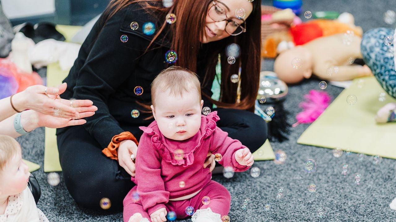 Bubbles floating during a multi sensory baby development class, supporting infant development and wellbeing.
