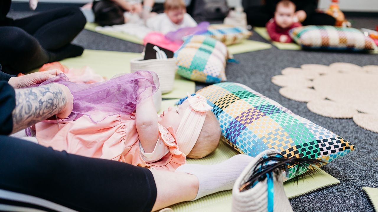 Baby and parent sharing a familiar, calm moment during a baby class, illustrating how repetition helps babies feel safe and settled.