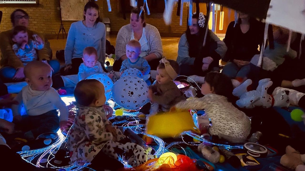 Babies exploring glowing fibre optic tails during a sensory baby class led by The Baby Class Expert, showcasing light play for infant development