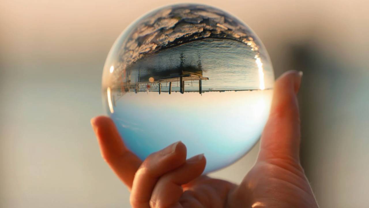 glass ball in someone's hand reflecting the scenery upside down
