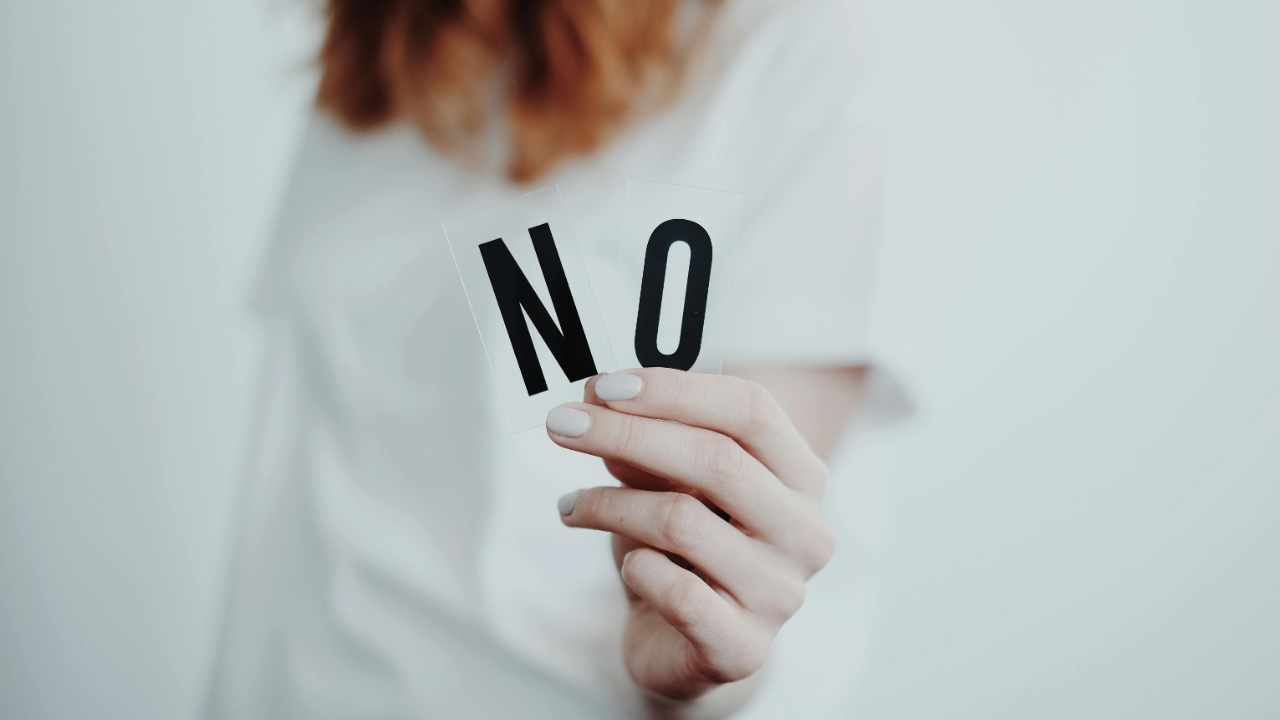 Anonymous person holding up a sign saying 'No' - signifying boundaries in sex & relationship therapy