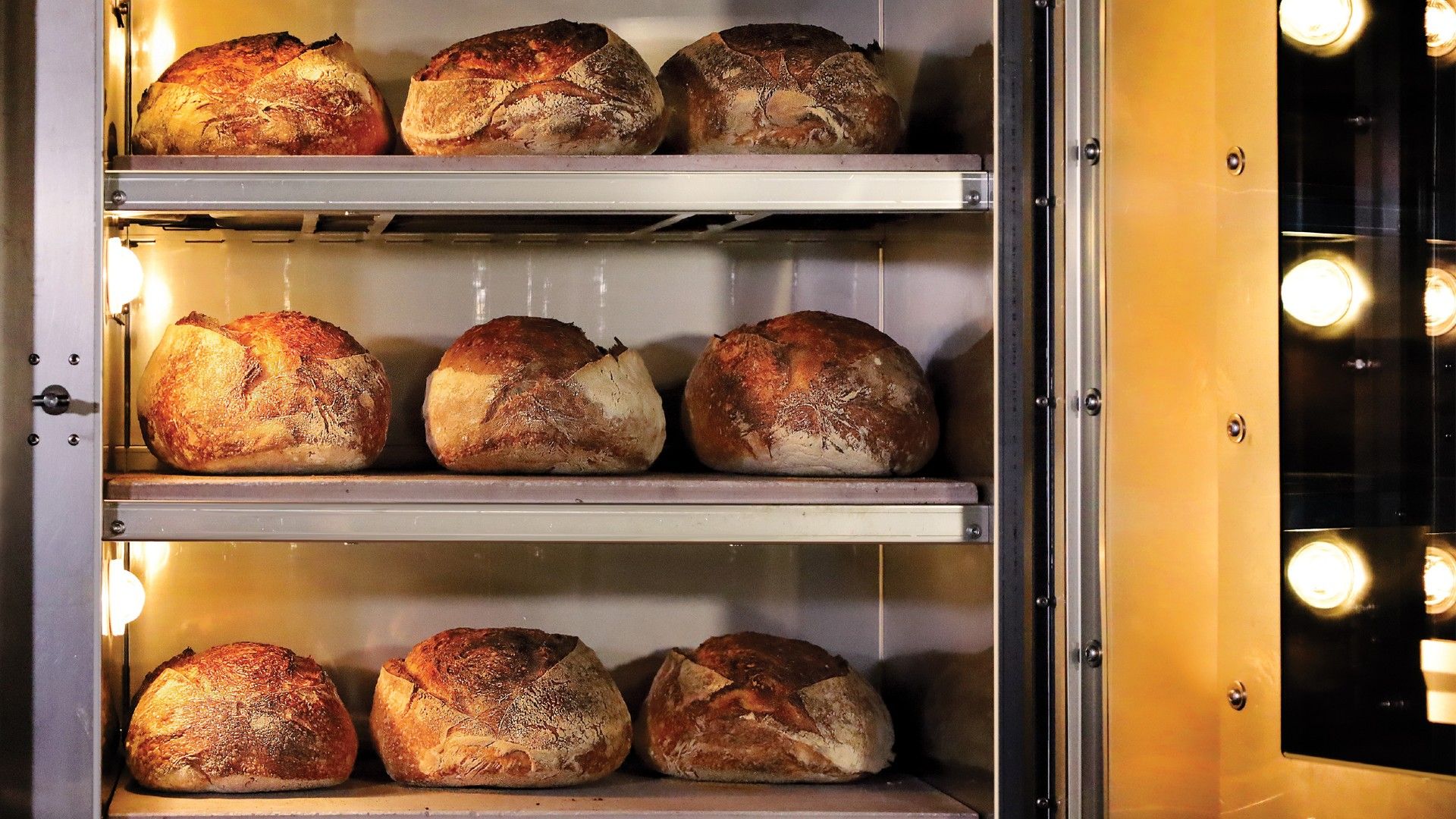 The inside of a MyForno Cottage Bakery Oven filled with bread on 3 racks