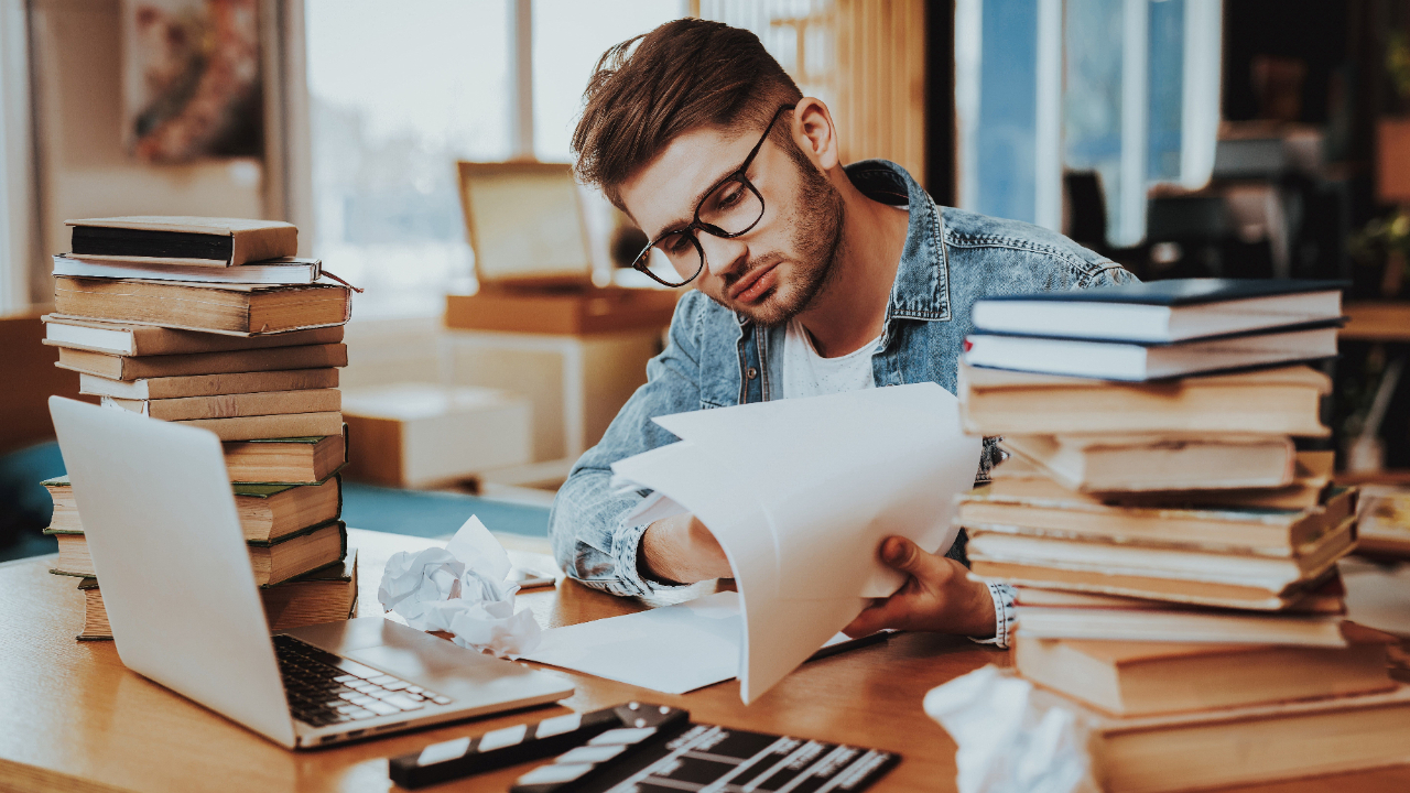 A nonprofit professional reviewing grant documents, illustrating the complexities of choosing between individual and joint grant applications for an upcoming project.