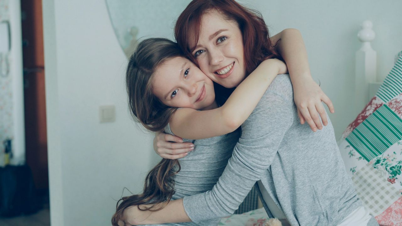 Mamă care își ține copilul în brațe într-un moment de conexiune emoțională, simbolizând relația dintre starea emoțională a mamei și dezvoltarea copilului.