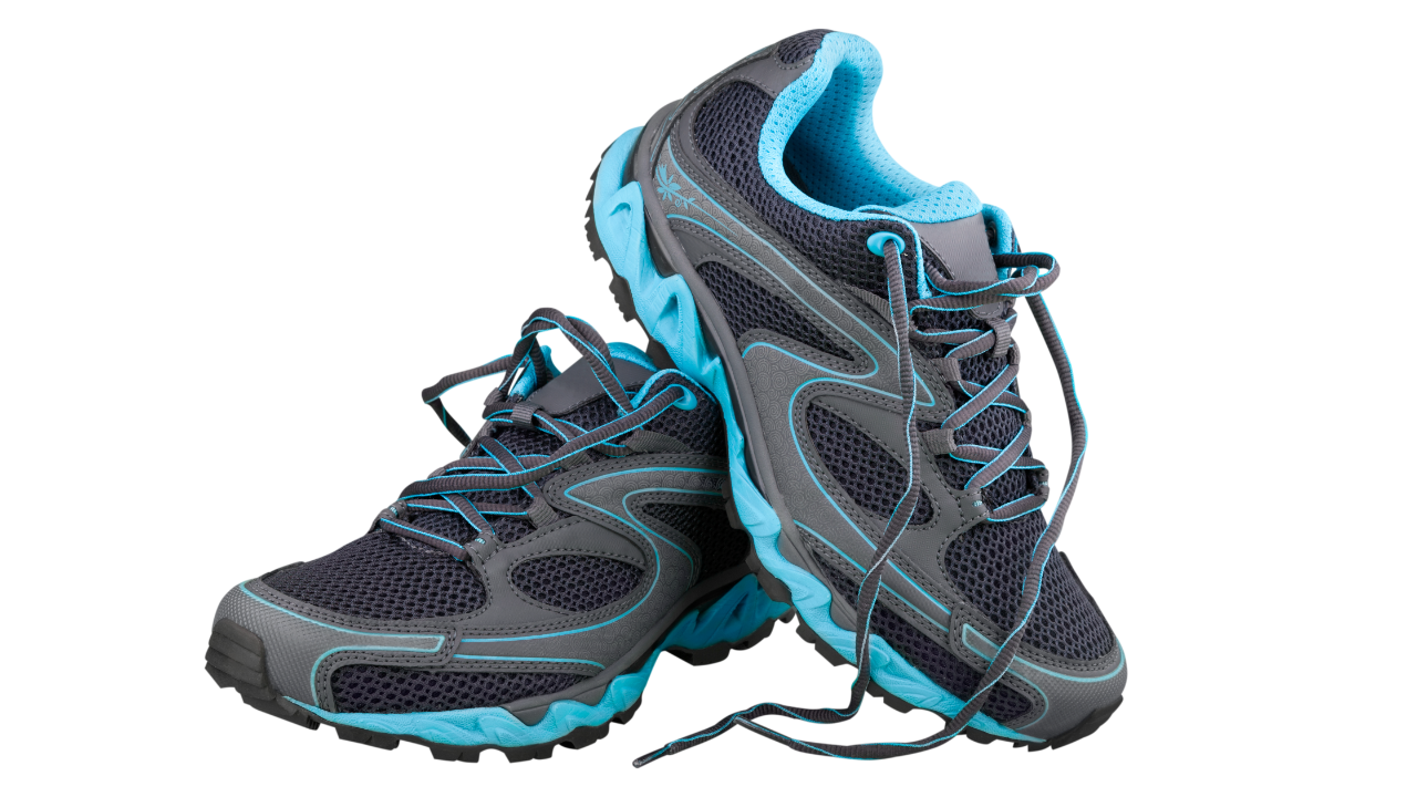 Pair of carbon-plated running shoes on a track with worn soles after mixed training sessions