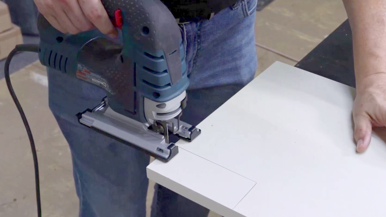 A jigsaw cutting a notch into a panel
