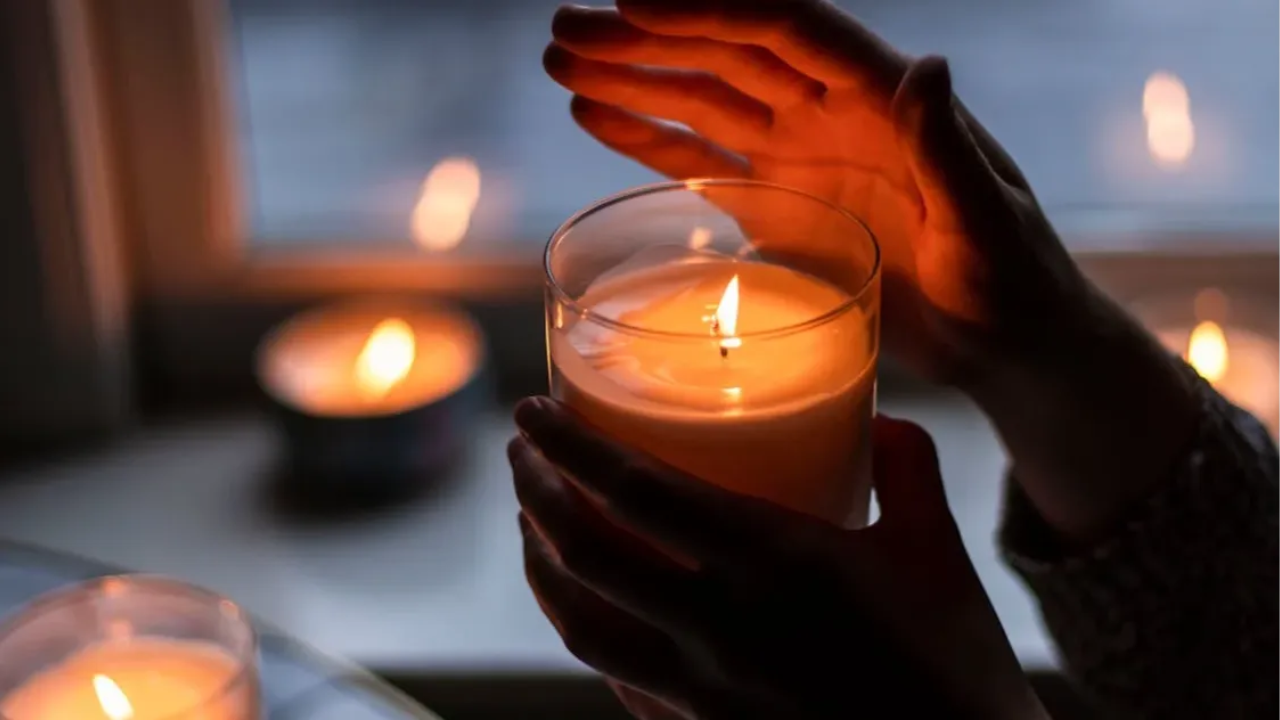 Photo of Person Holding Scented Candle