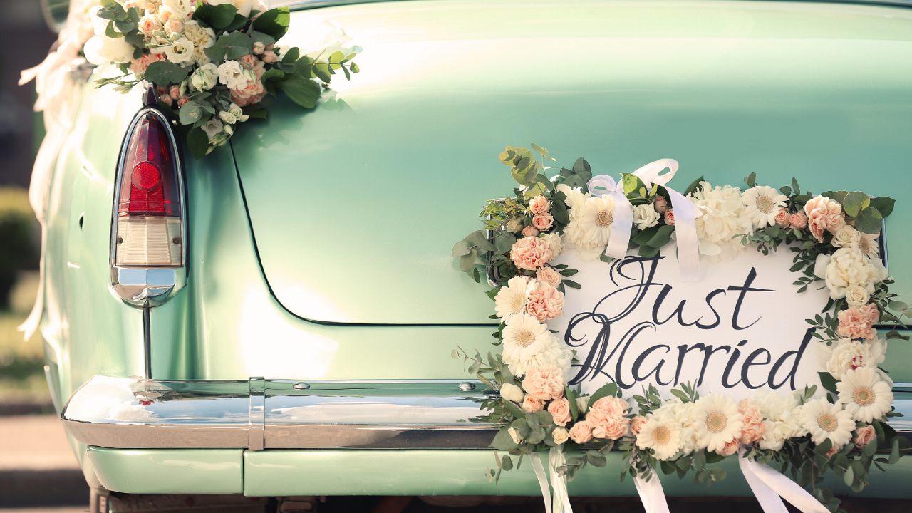 Mint green vintage car decorated with white and blush flowers and a floral “Just Married” sign on the back, symbolizing a joyful LDS temple wedding send-off and the thoughtful small details that make the day memorable.