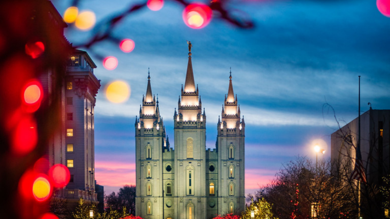 Salt Lake City Temple glowing at dusk with Christmas lights, symbolizing faith and celebration during the holiday season.