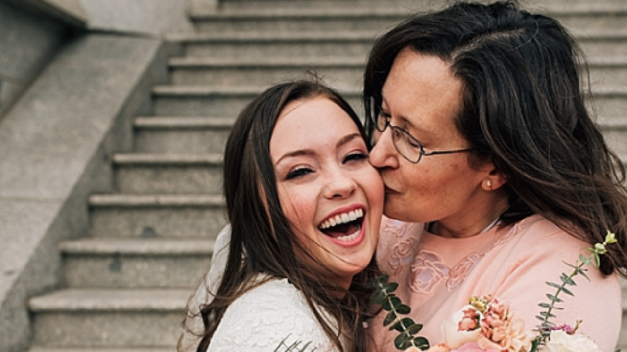Mother of the Bride kissing her happy daughter on her LDS temple wedding day
