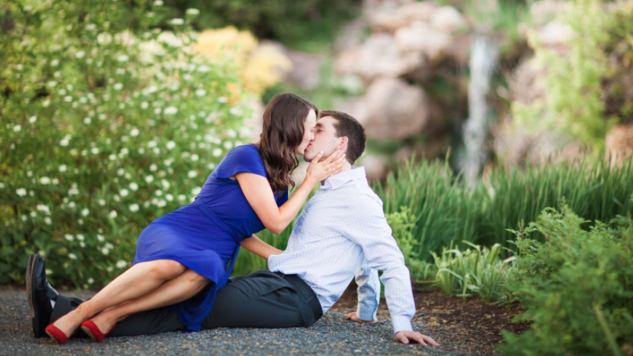 Newlywed couple sitting together in a peaceful garden sharing a romantic moment, symbolizing connection and the beginning of their honeymoon journey.