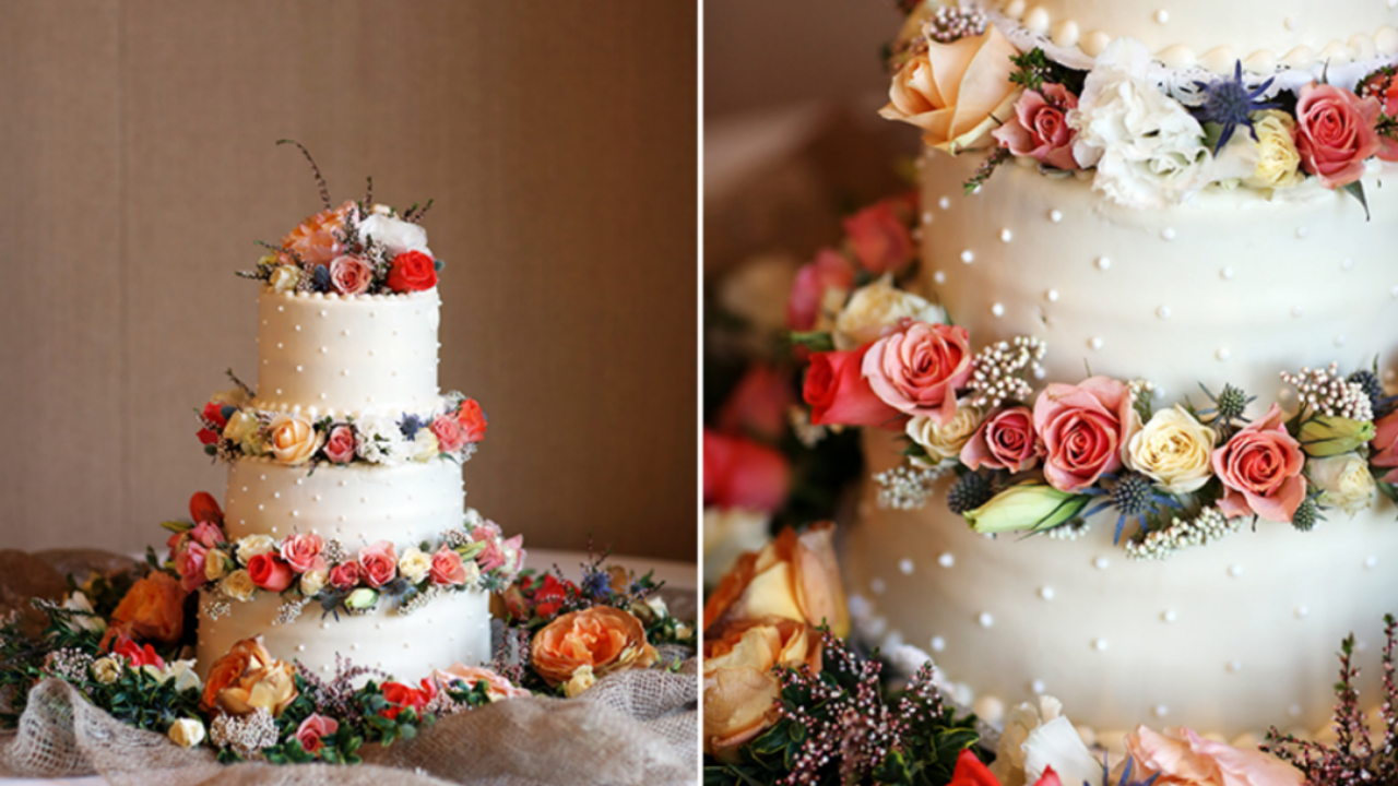 LDS wedding cake decorated with pastel roses on white frosting, three tiers, surrounded by floral accents—image for LDS wedding cake serving guide infographic.