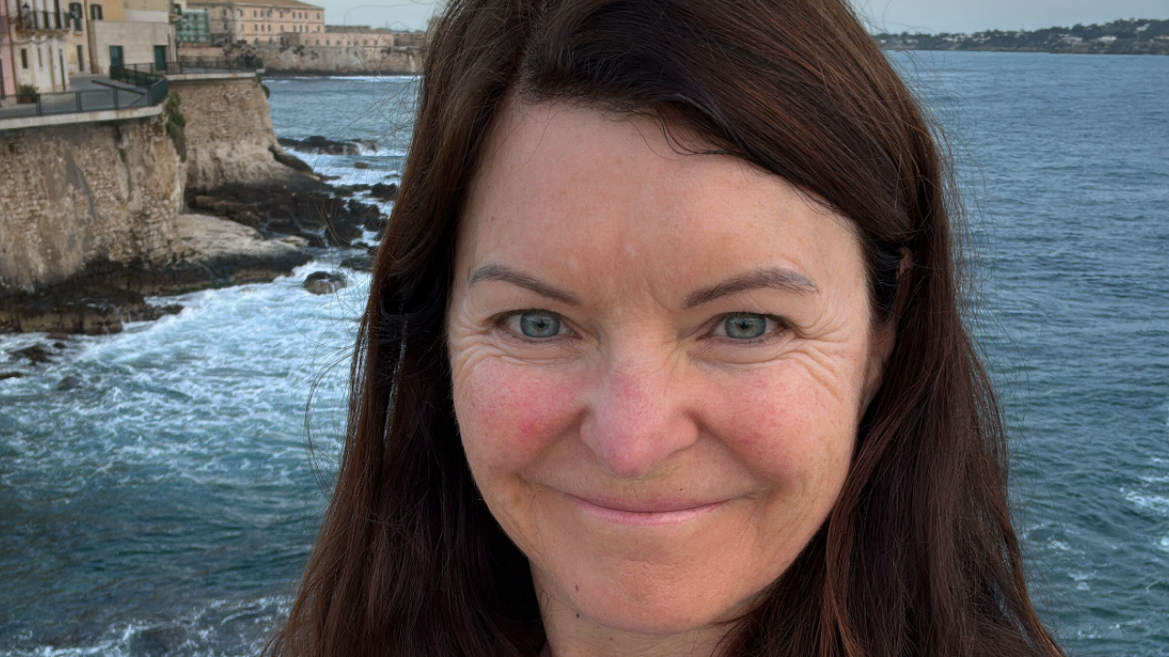 Mette, coach, smiler ut mot havet