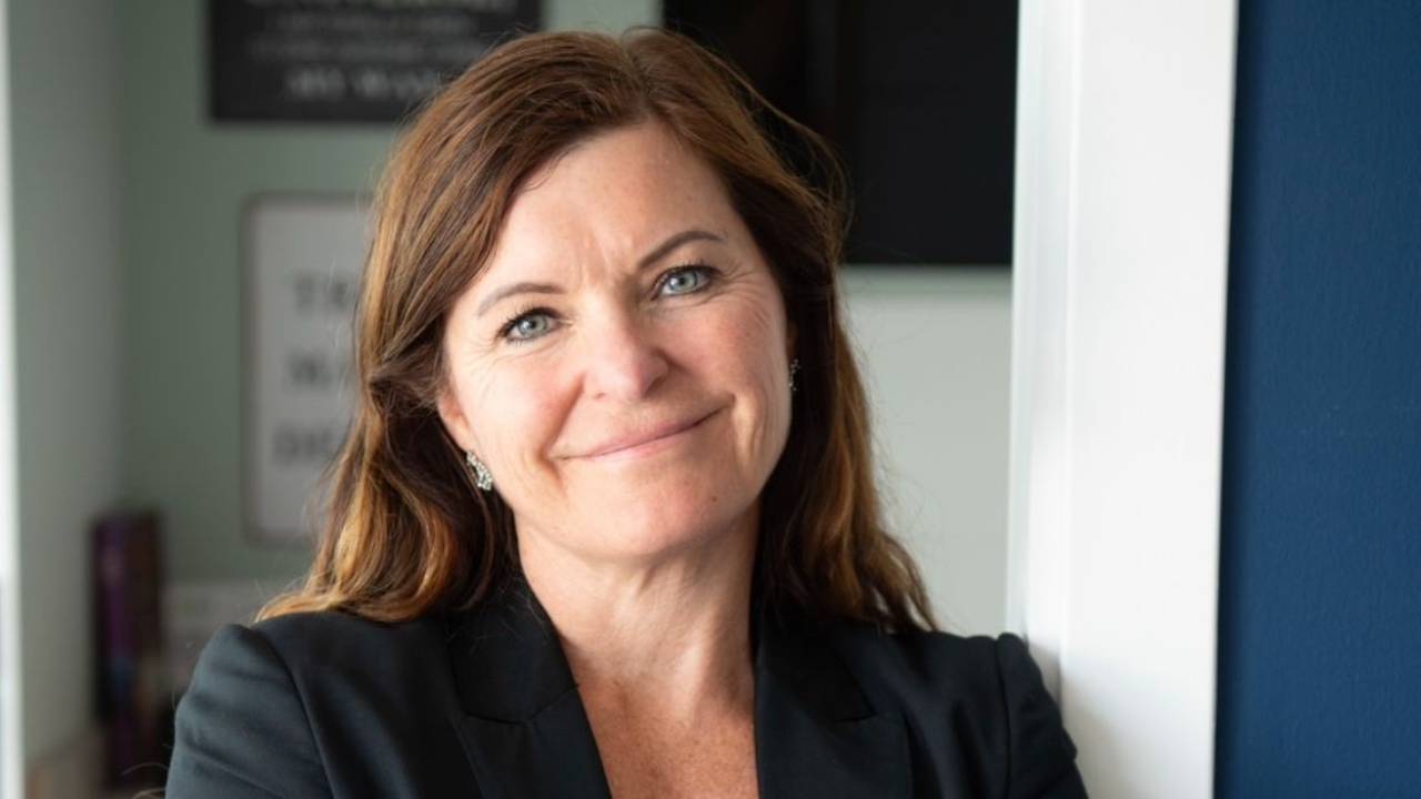 Kvinnelig leder, grûnder som smiler til kamera