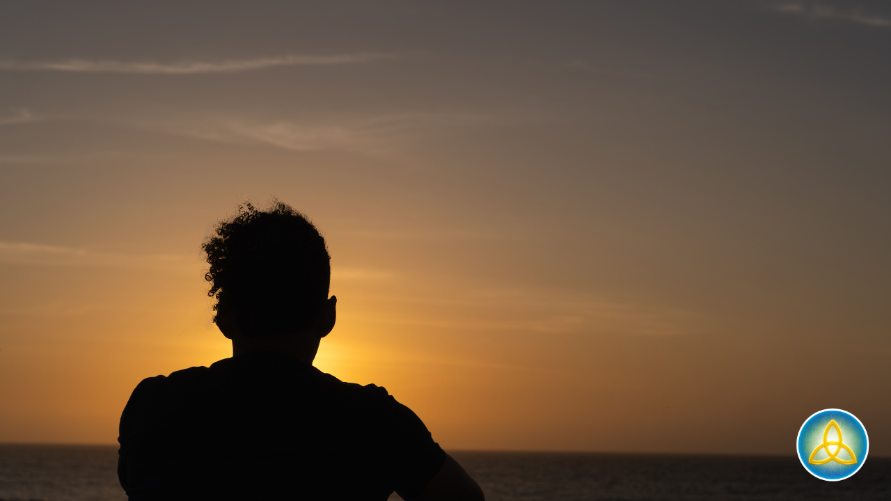Silhouette of a man gazing over the ocean at sunset — emotional awareness and mindfulness for men.