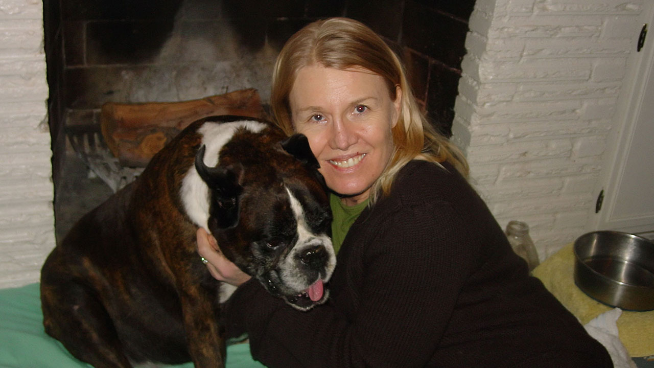 Sora and Michelle Nichols sitting by the fireplace on Sora's dog bed. We were so grateful for the chance to say a peaceful goodbye to Sora after she woke from her natural dying process for one &ldquo;last bloom