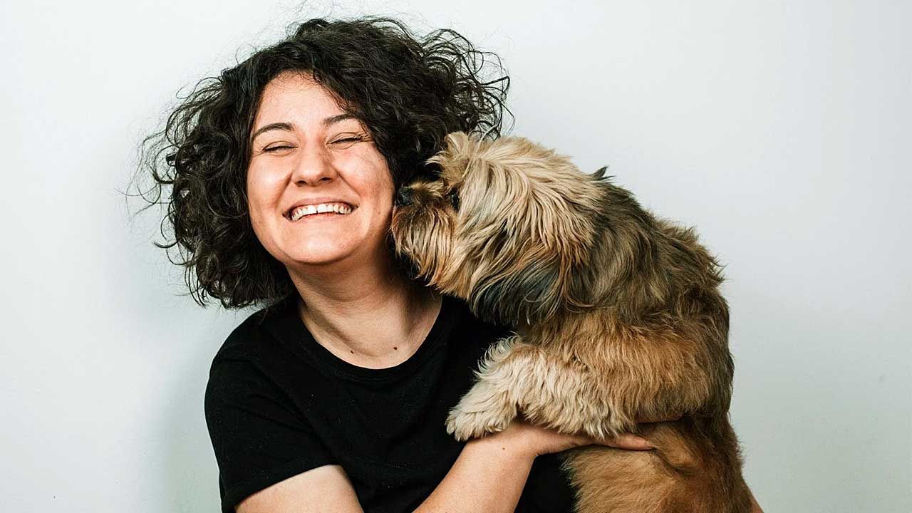 AHELP Project - Blog post, How to Write a Pet Obituary (With Examples) - A Legacy-Building Practice for Families Navigating Pet Loss, photo of Border Terrier kissing dog mom on cheek.