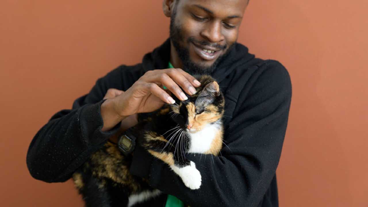 Photo of Daniel holding and bonding with the newest member of his family, calico kitty Jasper. Photo of Daniel holding and bonding with the newest member of his family, calico kitty Jasper.