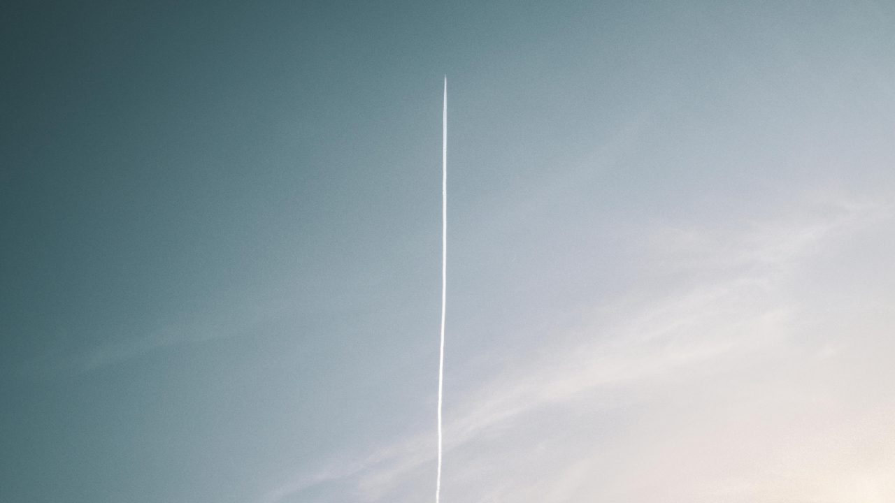Airplane flying across the sky with a visible contrail forming a clear boundary