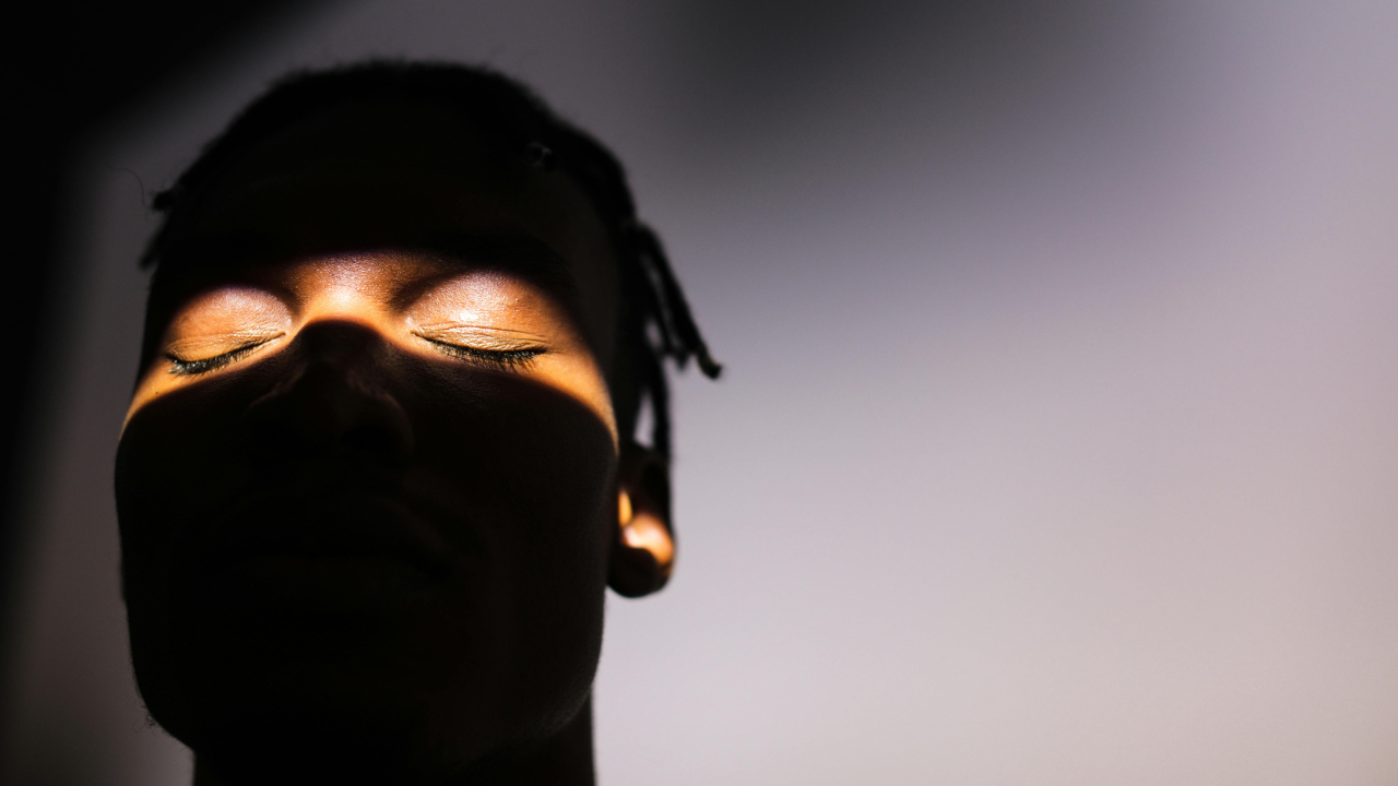 Man's face with eyes closed partly in shadow. Symbolizes the way that many men are blind to the good change happening in their marriage.