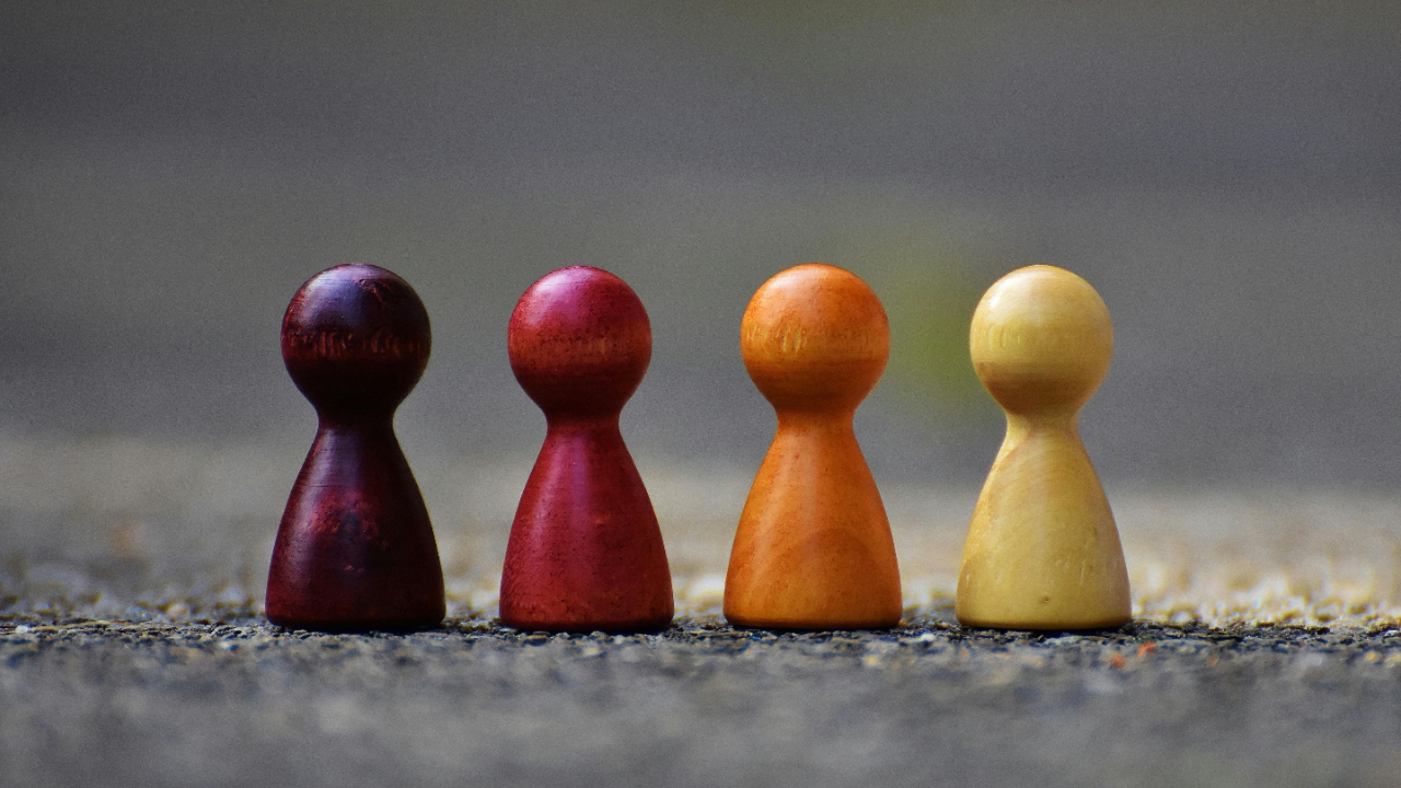Four pawns that look like people placed next to each other, symbolizing friendship and community 