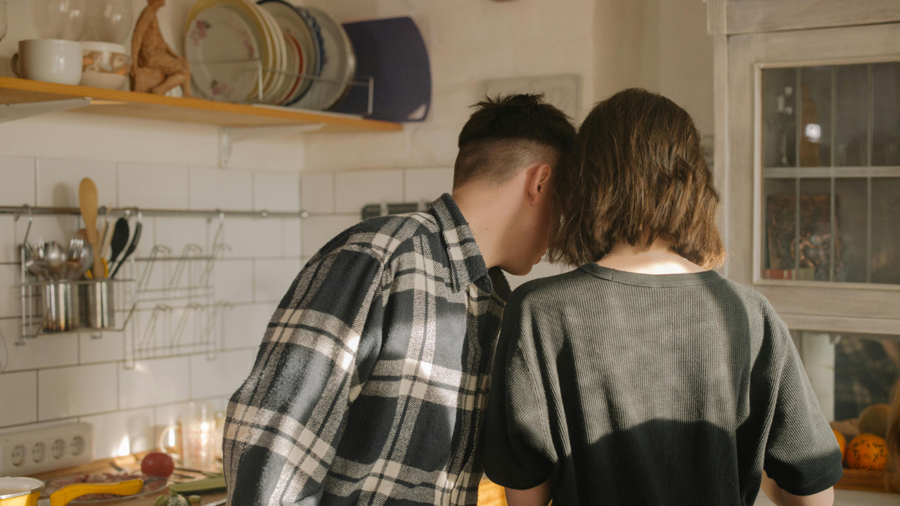 A man and woman roommate stand closely next to each other, indicating their emotional closeness and intimacy.
