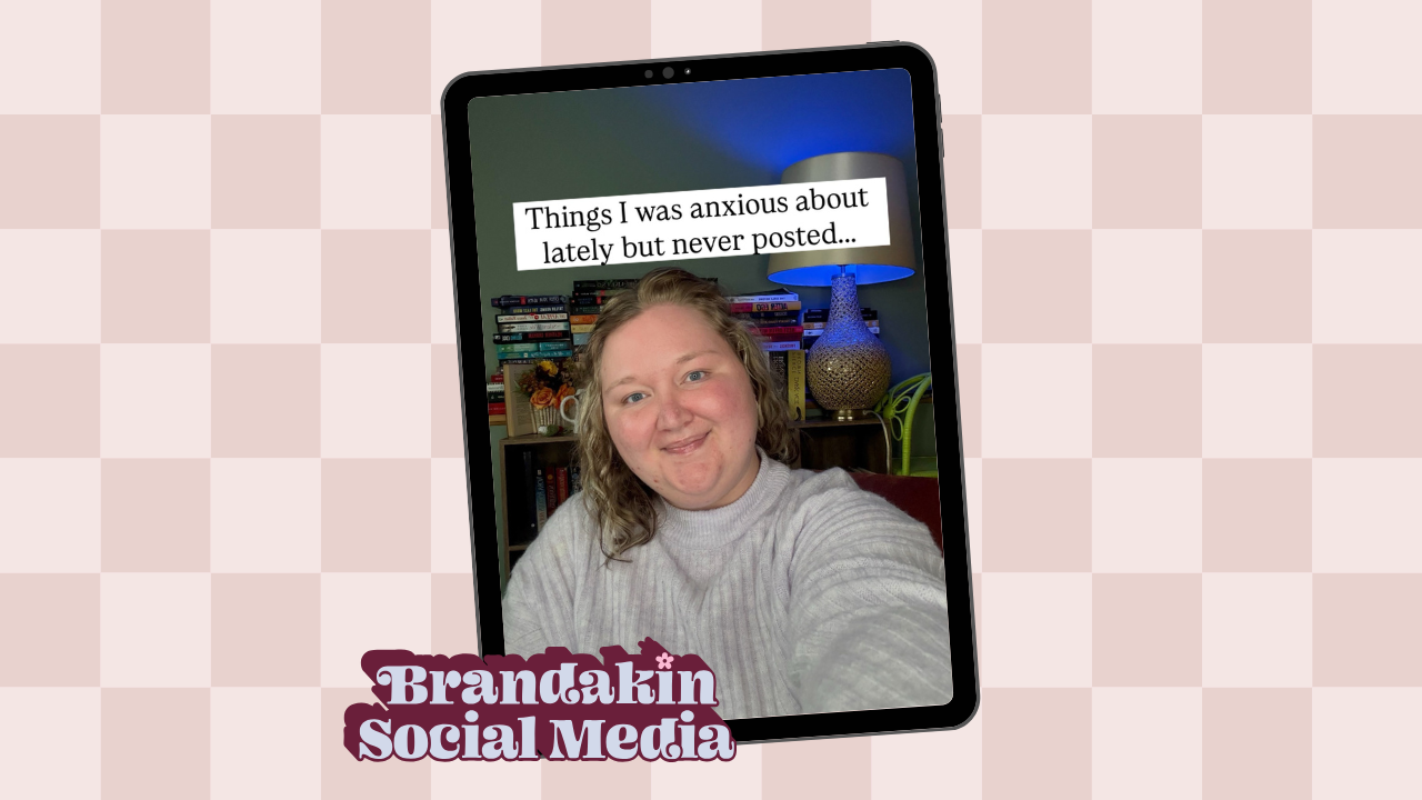 A smiling woman in a gray sweater sits in front of a colorful bookcase and lamp, with the text "Things I was anxious about lately but never posted..." displayed above her on a tablet screen. The background features a pink checkered pattern and a logo in the bottom left corner that reads “Brandakin Social Media.”