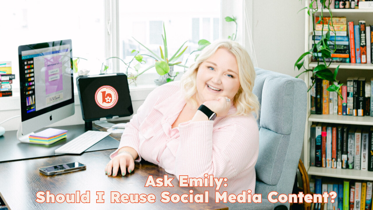 Emily sitting at a desk in a bright home office, smiling at the camera. A desktop computer and tablet are on the desk, surrounded by plants, books, and office supplies. Text overlay reads: "Ask Emily: Should I Reuse Social Media Content?