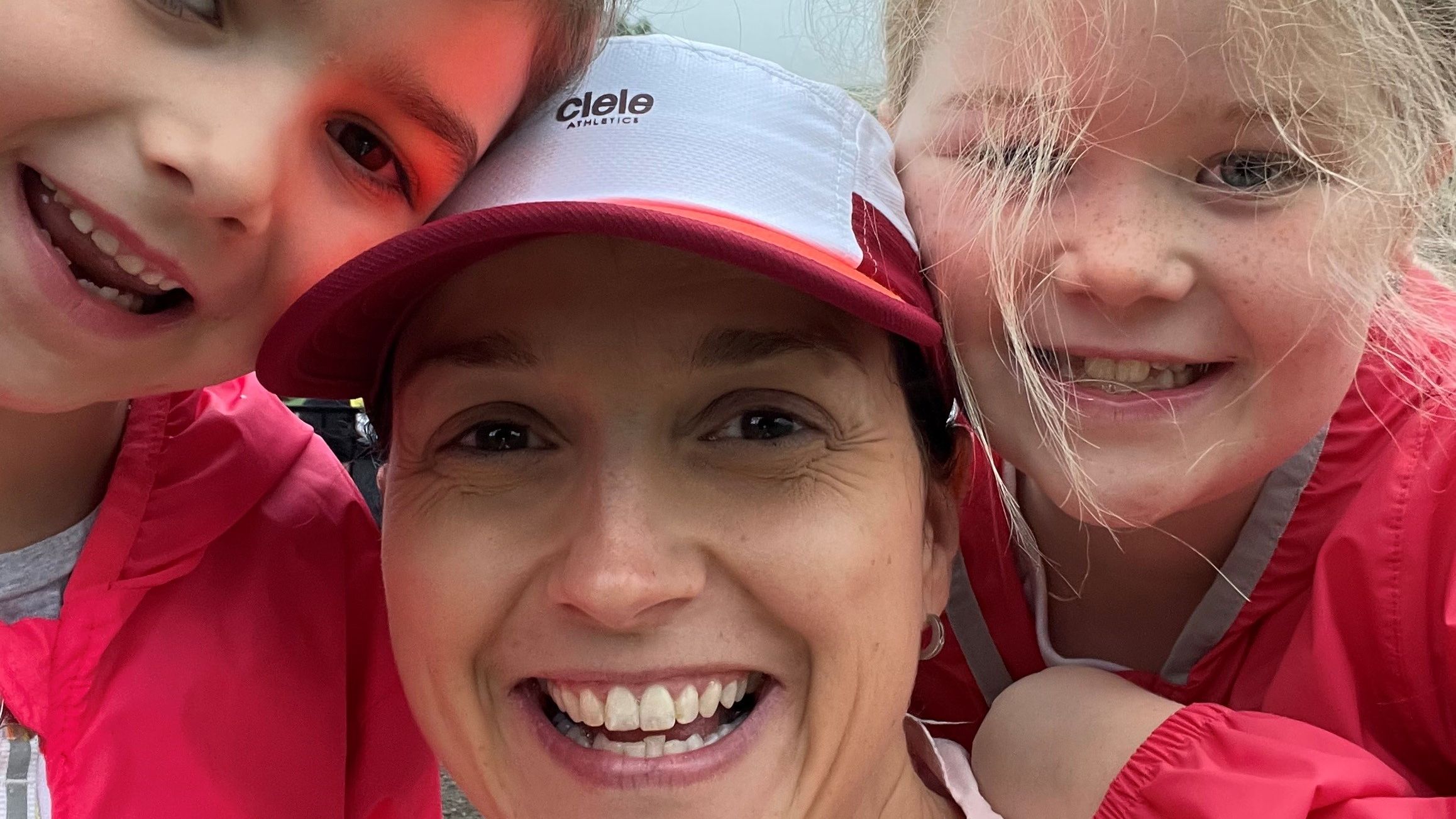 A runner mom with her two daughters waiting for a race to start, showcasing family support and the joy of running together. Inspiring beginner runners and busy moms.
