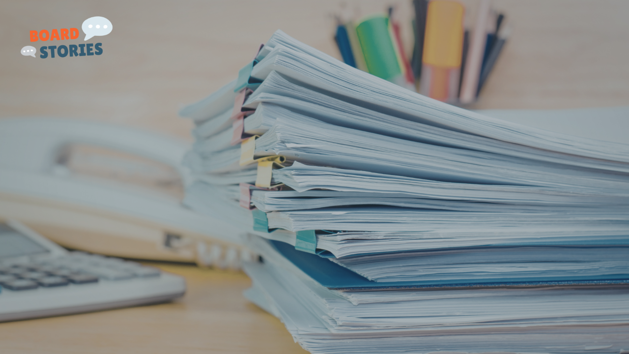 Stack of documents with sticky notes on a desk, representing board meeting materials