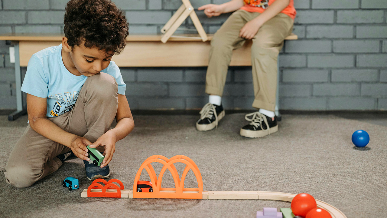 Young boy concentrating on playing with toy cars