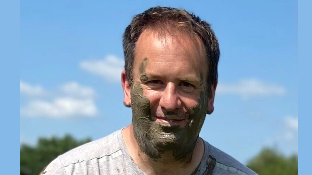 A photo of a leader standing outdoors after a challenge—mud-splattered boots or hands—representing real, messy transformation.