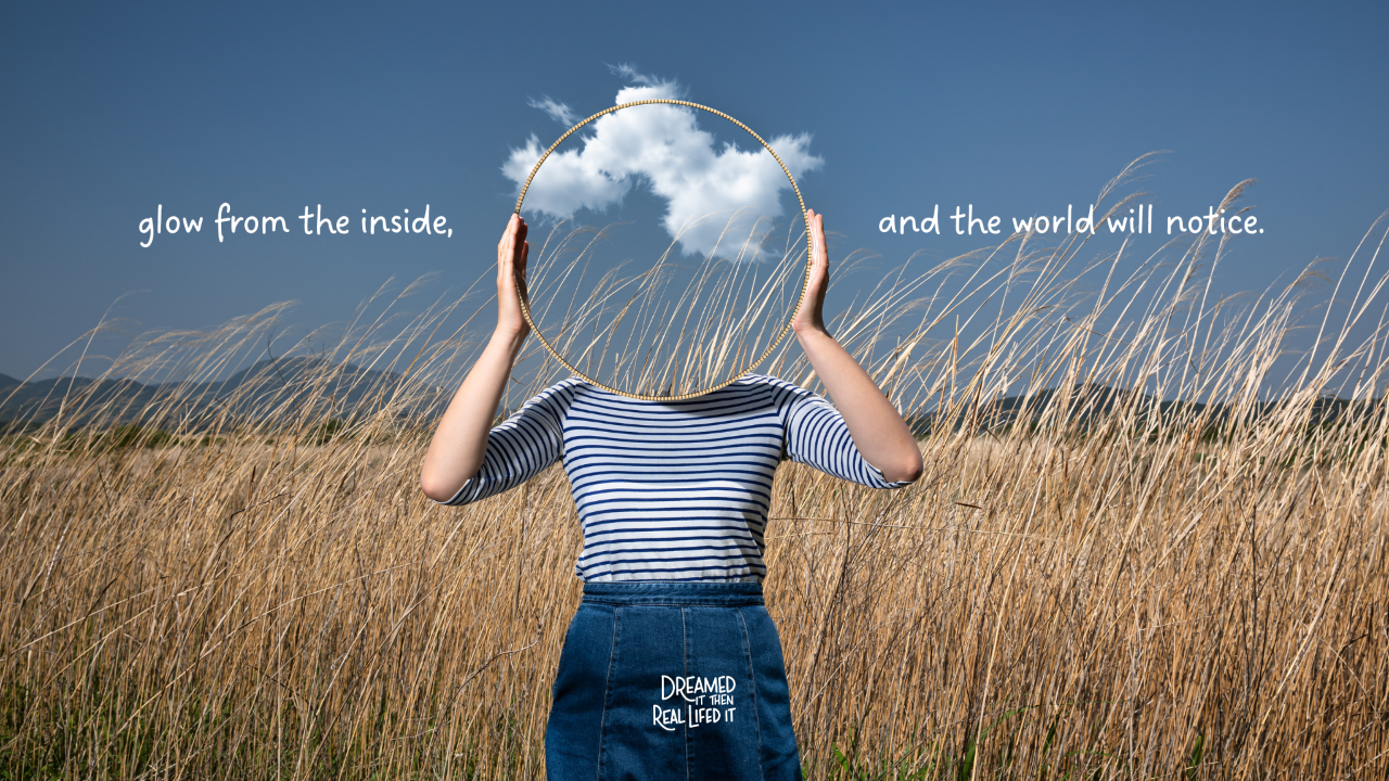 Dreamed It Then Real Lifed It podcast, image of girl standing in wheat field holding mirror in fron of her face that shows blue sky with shite clouds