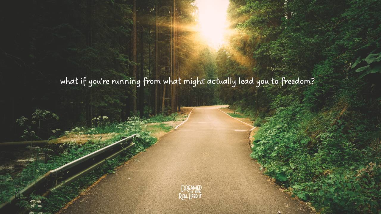 Dereamed It Then Real Lifed It podcast image of dirt road leading into forest with sun shining through trees and white words across middle that say "what if you're running from what might actually lead you to freedom?"