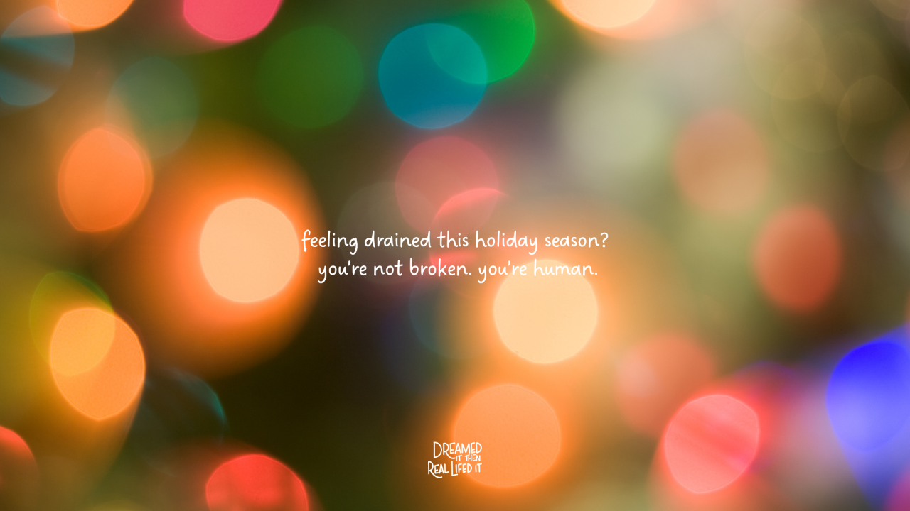 Dreamed It Then Real Lifed It podcast image of bokeh brightly colored holiday lights with text in white saying feeling drained this holiday season? you're not broken, you're human