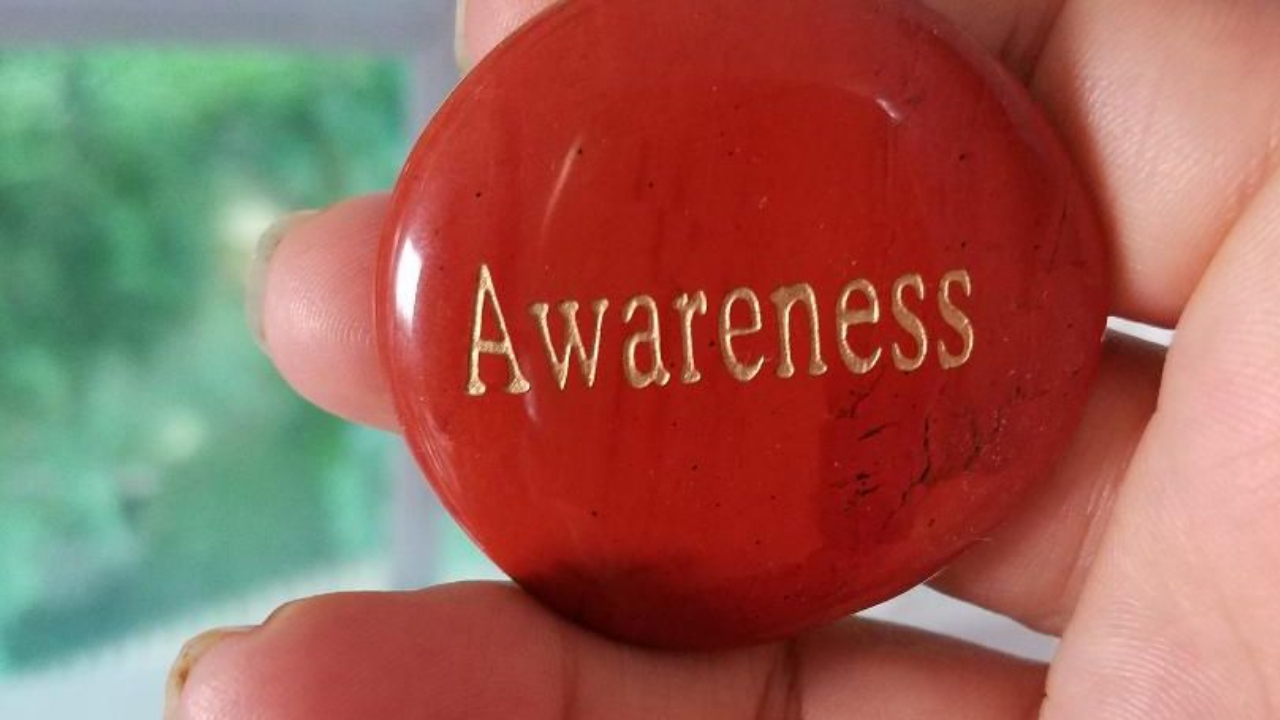 red rock with the word AWARENSS written in gold letters