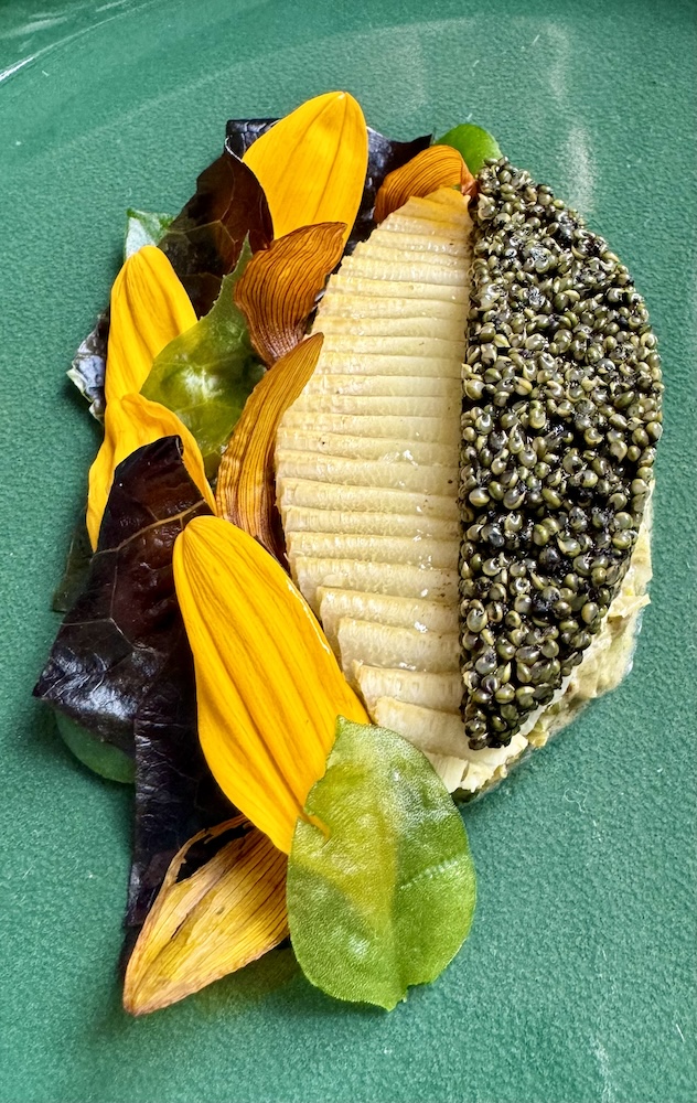 Sliced artichoke and seaweed pearls on a plate at Eleven Madison Park
