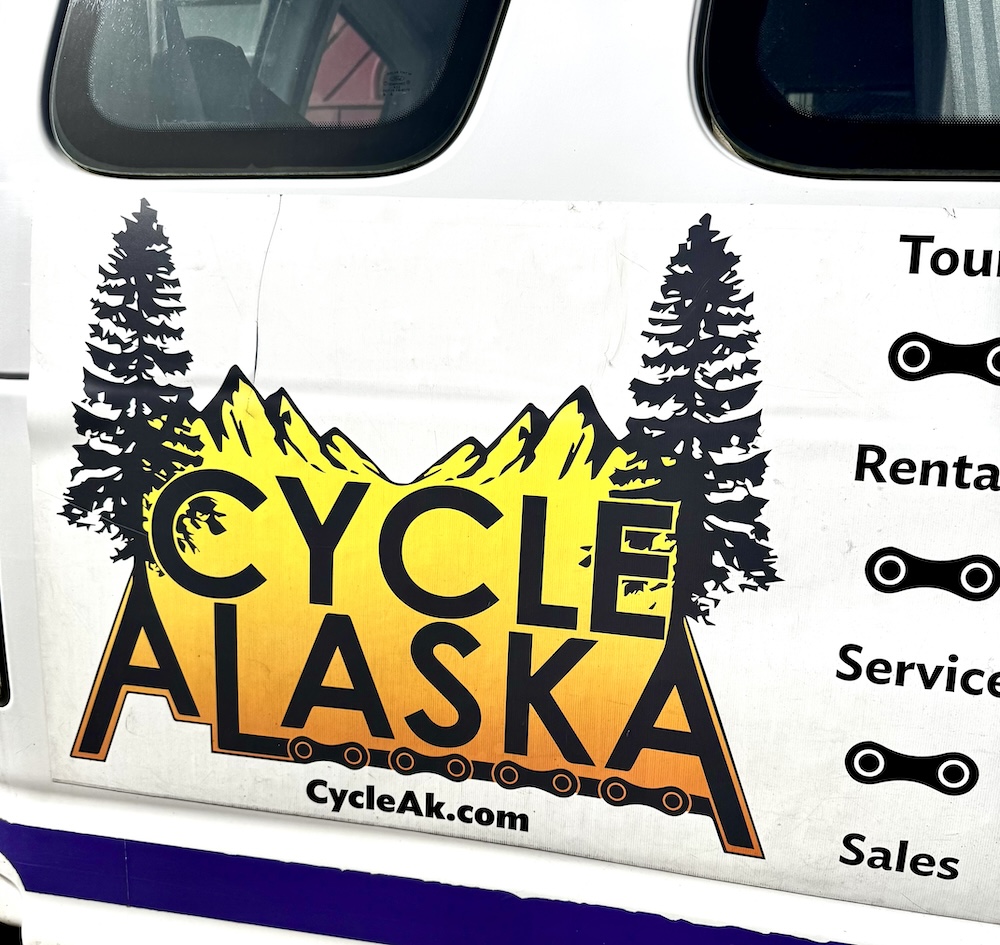 Cycle Alaska van with yellow mountains and spruce trees logo, Rental Sales Service text visible