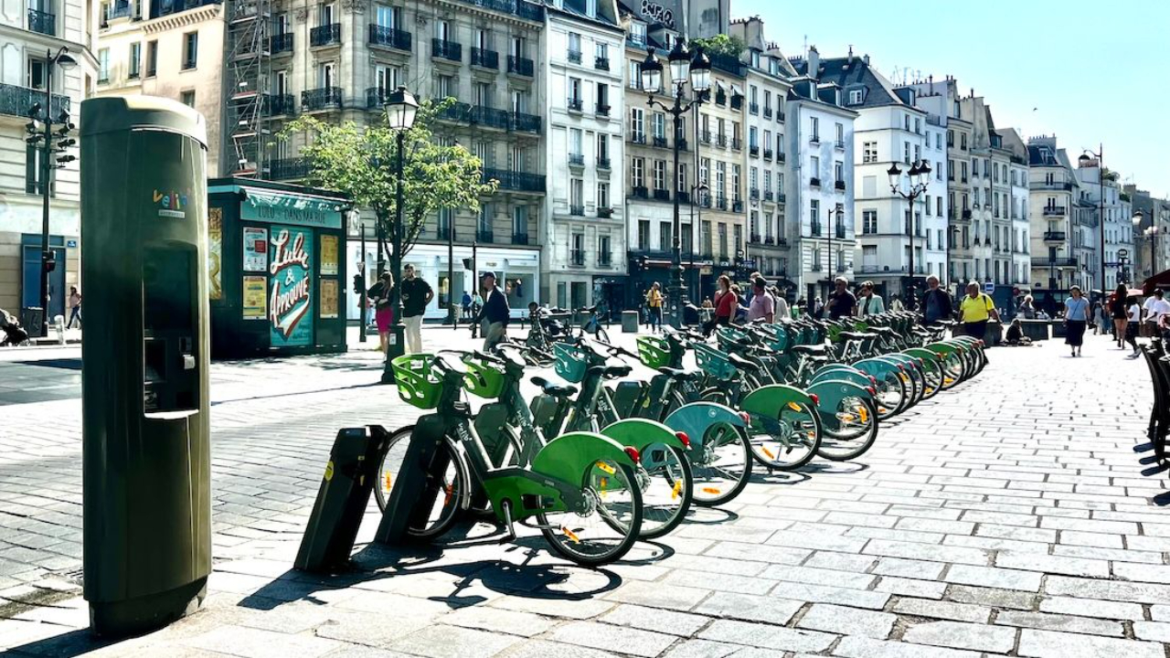 Green Velib bikes on Paris street parked in docks.