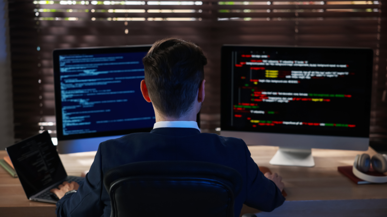 IT-Administrator überwacht System- und Sicherheitsdaten auf mehreren Monitoren als Darstellung von proaktivem IT-Monitoring