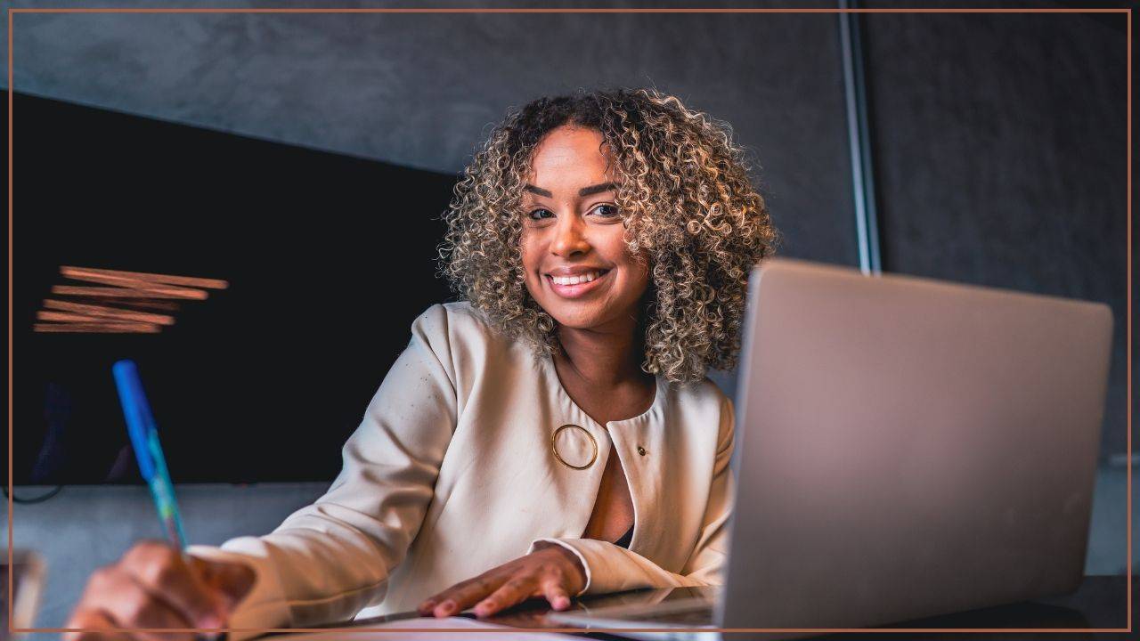 happy office worker sitting in front of a computer