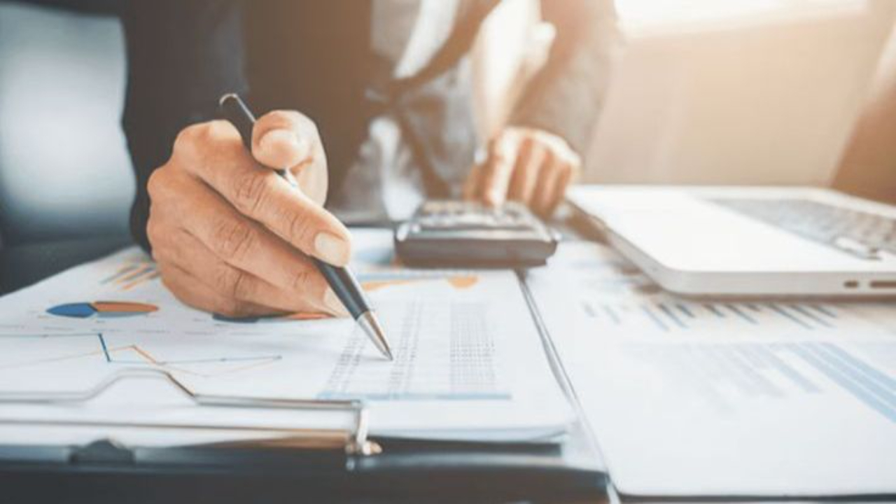 Business professional analyzing financial reports and calculating cash flow to identify timing mismatches between accounts receivable and accounts payable for better liquidity management.