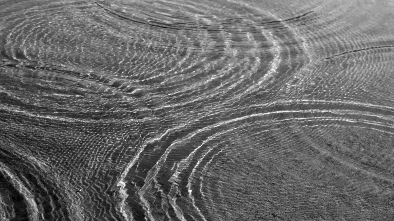 Water ripples in black and white showing intersecting circular patterns, representing the yes frequency and pattern recognition in healing