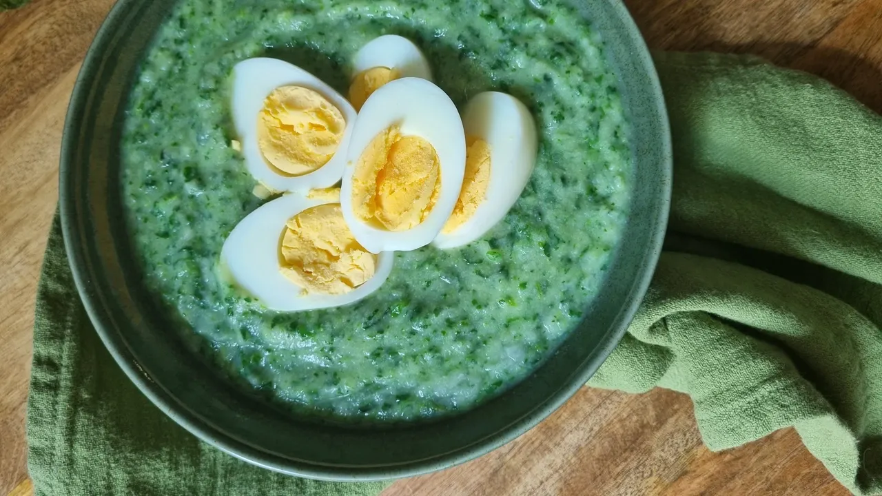 Kulhollinen pinaattikeittoa kananmunalla koristeltuna.