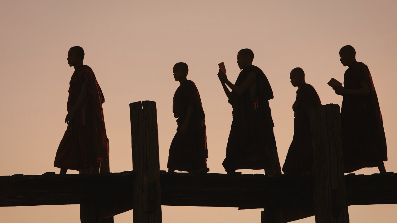 Monks silhouetted at sunset